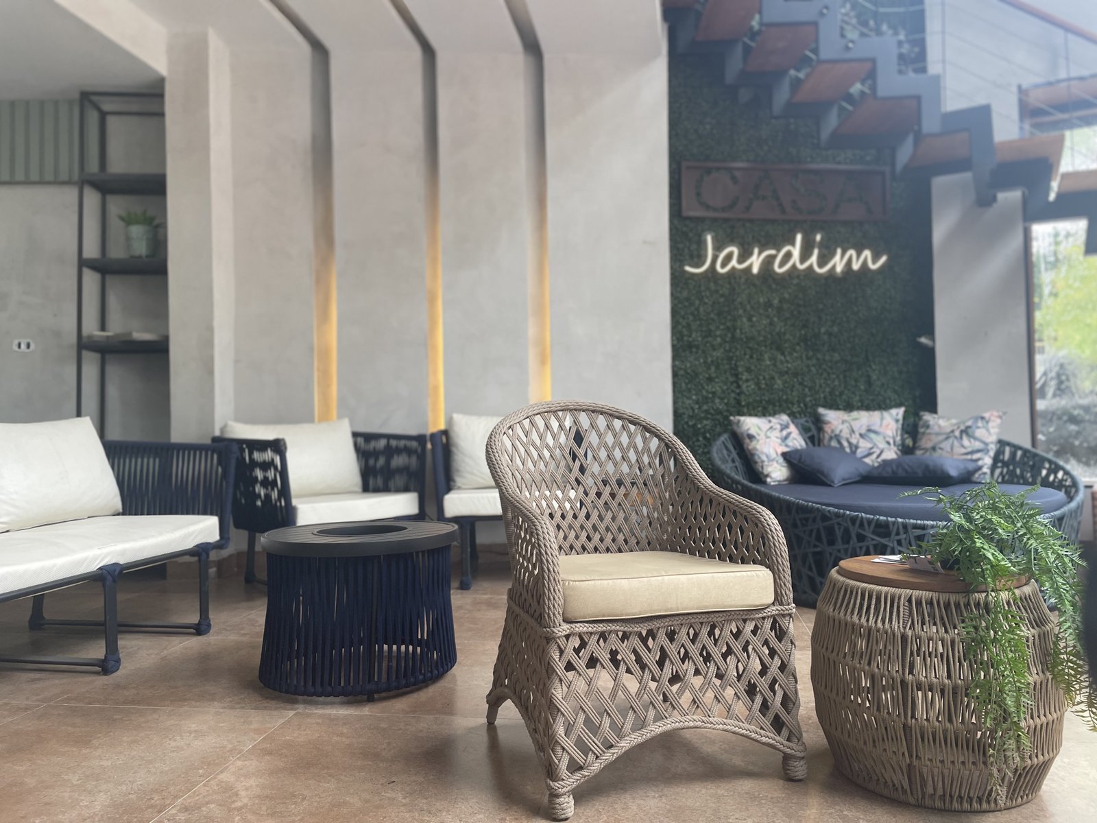 Lounge com poltrona trançada, sofás em corda náutica e mesas laterais