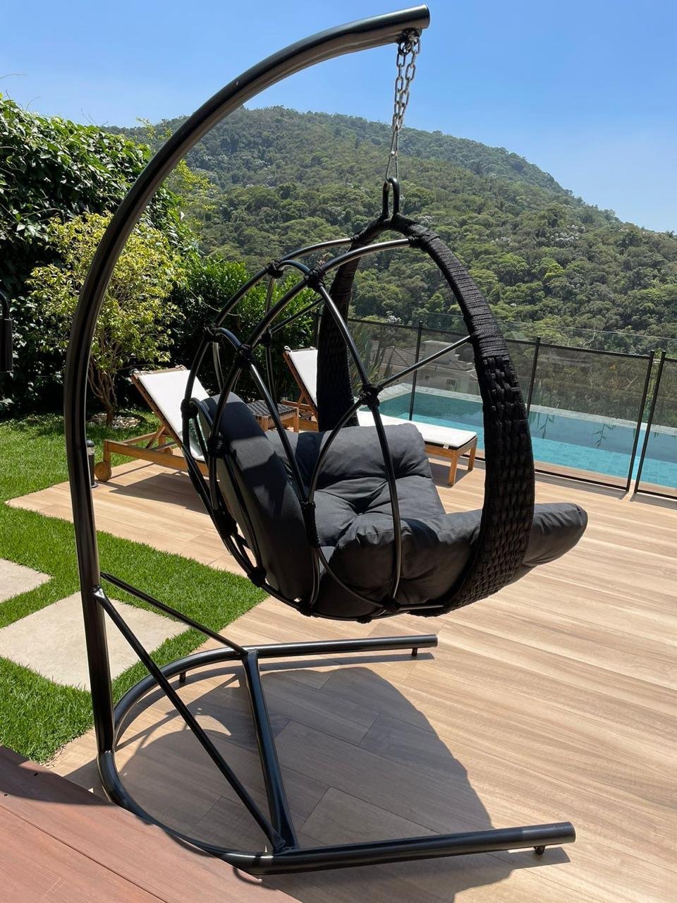 Balanço concha preto em corda náutica com almofadas grafite, ao lado da piscina