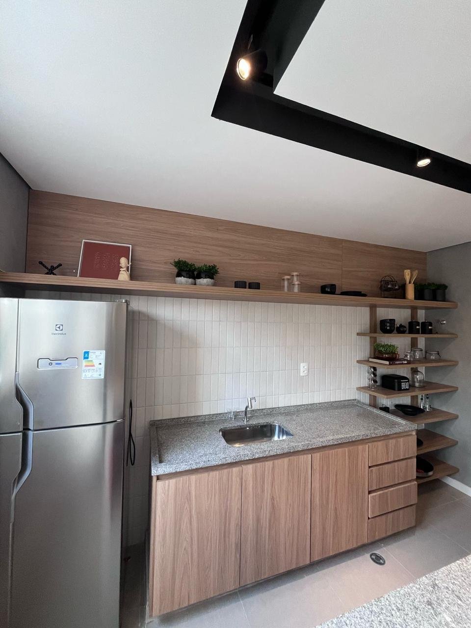 Cozinha planejada com armários em madeira e prateleiras
