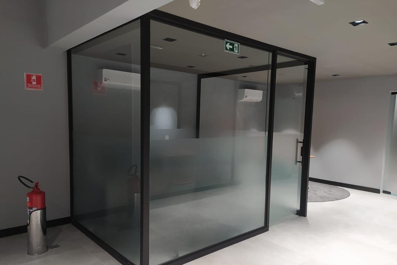 Sala em formato de cubo de vidro com perfis pretos